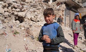أطفال ينتظرون توزيع الطعام عليهم خلال أزمة كوفيد-19 في حلب بسوريا.