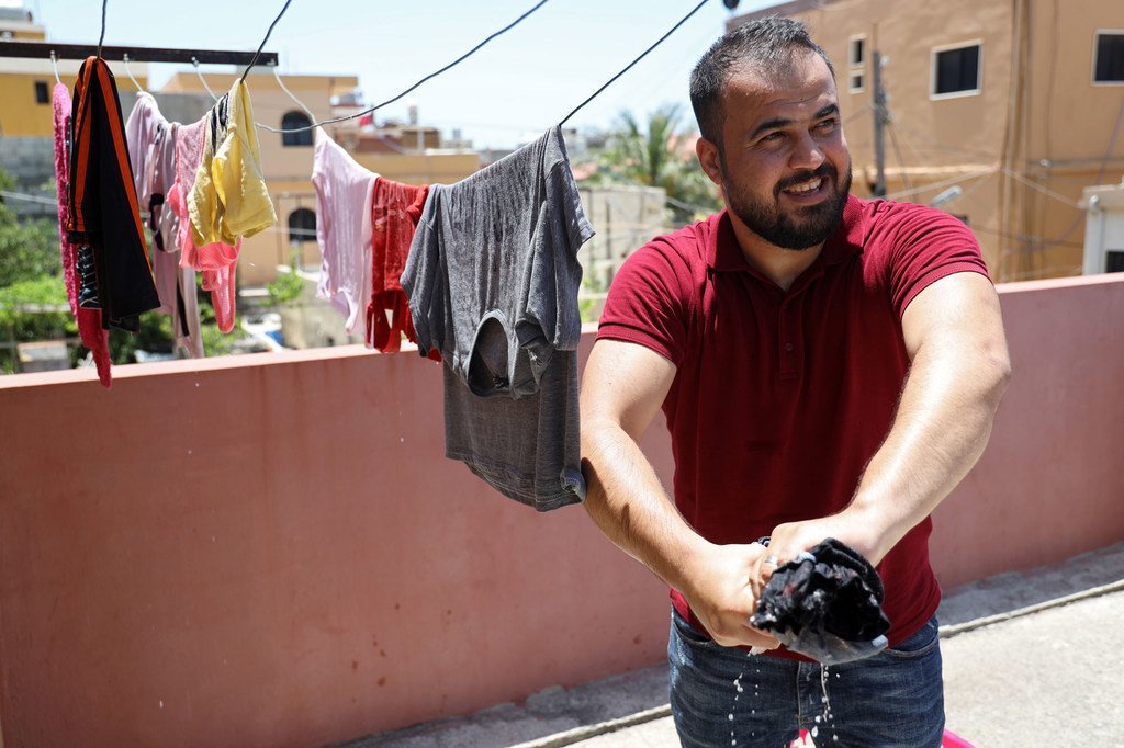 اللاجئ الفلسطيني، محمود شراري يساعد في الأعمال المنزلية في منزله في مخيم الرشيدية في لبنان.