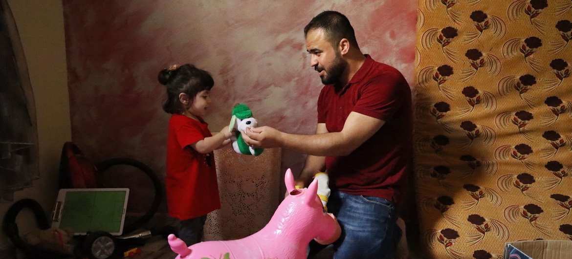 Mahmoud Charary, réfugié palestinien au Liban, joue avec sa fille d'un an.