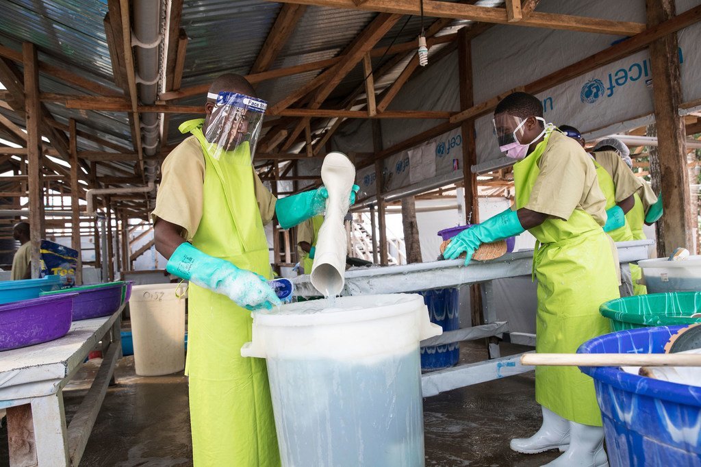 Le personnel d'un centre de traitement d'Ebola à Butembo, dans l'est de la RDC, désinfectent leurs bottes et nettoient leurs vêtements. 