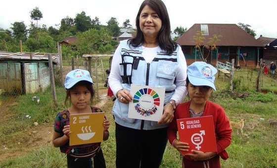The UN Resident Coordinator in Guatemala, Rebeca Arias, Flores promotes the Sustainable Development Goals with the help of two young children.