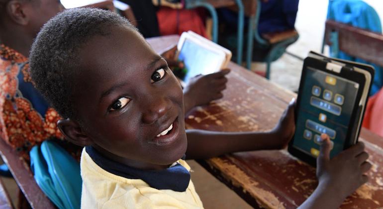 Des enfants vont en classe avec leurs tablettes à l’école Radi, dans le village de Safi, dans le sud du Niger.