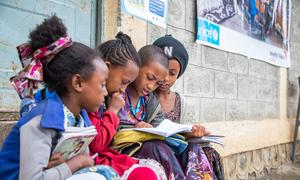 इथियोपिया के टीगरे के एक स्कूल में कुछ बच्चियां यूनीसेफ़ समर्थित स्कूल के बाहर पढ़ रही हैं. 