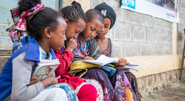 Meninas sentam juntas e estudam do lado de fora de uma escola apoiada pelo UNICEF no centro de Tigray, na Etiópia