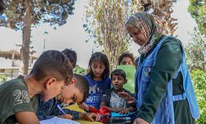 معلمة تابعة لليونيسف تقدم للأطفال جلسات دعم نفسي واجتماعي في مركز تعليمي متكامل في ريف حلب الشرقي، سوريا.