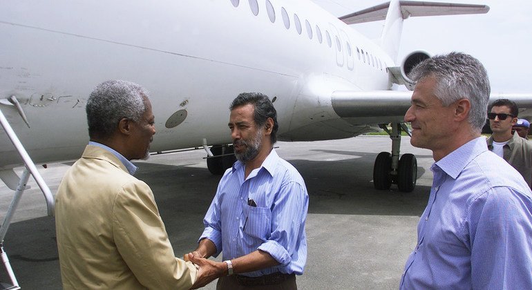 O secretário-geral Kofi Annan que chega em Dili, Timor-Leste, é recebido pelo líder da independência Xanana Gusmão. À direita está o administrador de transição da ONU, Sergio Vieira de Mello. 17 de fevereiro de 2000