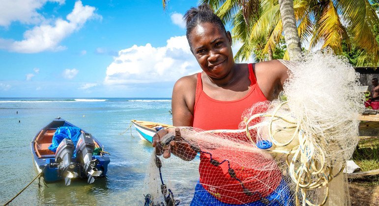 कैरीबियाई द्वीप डोमीनिका में एक महिला मछली पकड़ने के लिये अपना जाल तैयार करते हुए.