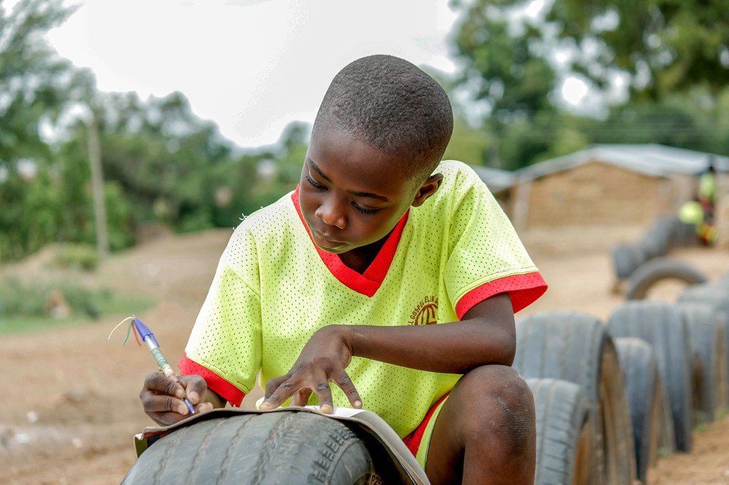 一个小男孩在加纳的户外学习。