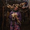 A woman in traditional dress in rural Turkey holds one of her animals.
