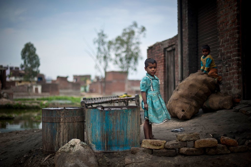 Des enfants jouent devant un atelier dans un bidonville de l'Uttar Pradesh, en Inde.
