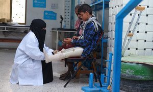 A doctor checks a young boy’s artificial limbs at a hospital in Aden, Yemen.