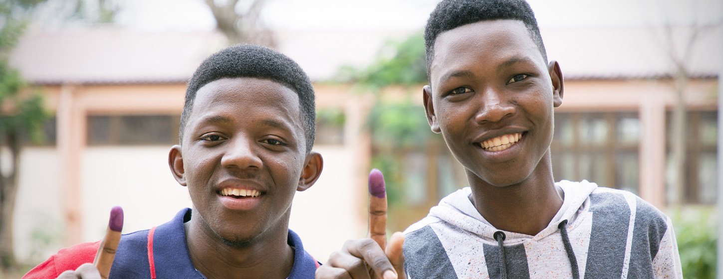 Jovens moçambicanos mostram o dedo marcado com a tinta azul após votarem nas eleições gerais em Moçambique.