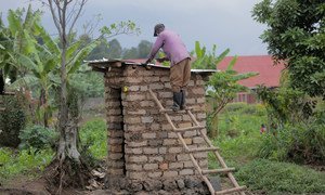 A professional builder constructs a toilet in his community in Burera district, Rwanda. The builder was trained by UNICEF and the NGO Society for Family Health to build hygienic and safe toilets.