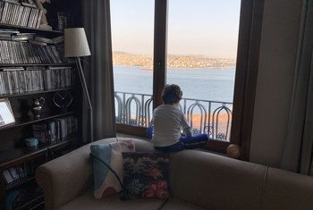 A seven-year-old child looks out the window in Istanbul, Turkey, during the COVID-19 emergency. Closure of schools, disruption of health services and suspension of nutrition programmes, due to the coronavirus pandemic, have affected hundreds of millions of children globally.