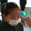 فحص درجة حرارة طفلة في منغوليا، بعد أن قدمت اليونيسف أجهزة لقياس درجات الحرارة في المدارس ورياض الأطفال.