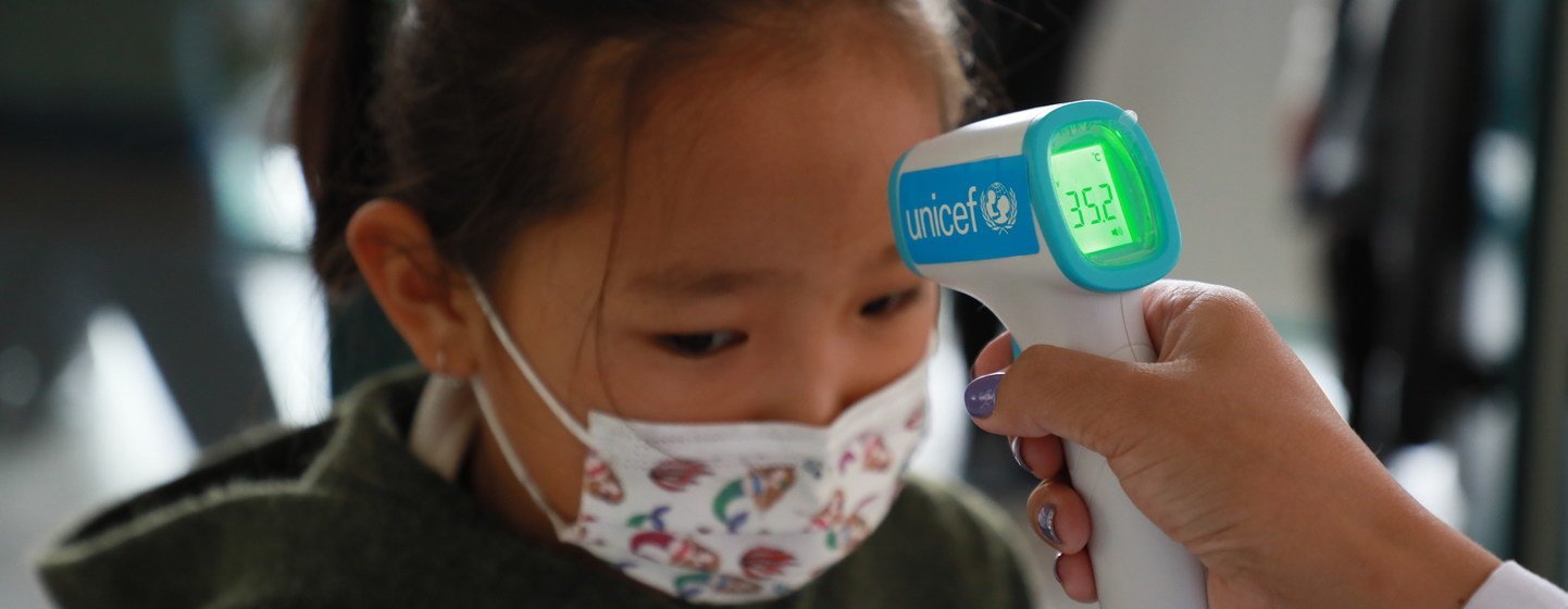 A young child has her temperature taken at school in Bayanzurkh district, Mongolia. UNICEF provided infrared thermometers to schools and kindergartens in the district as part of its COVID-19 prevention efforts. 