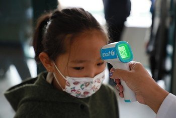 Toman la temperatura a una niña pequeña en Mongolia con un termómetro proporcionado por UNICEF para prevenir los contagios de COVID-19. 