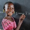 布基纳法索东部法达的一名女孩在重开后的学校黑板上写字。由于新冠大流行，该国的学校已关闭数月。
