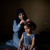 Wafaa, una refugiada siria de 32 años, sujeta el pelo de su hija Yasmine en su casa de Barja, Líbano. Las dos esperan su reasentamiento en Noruega.