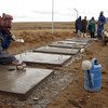 Contractors work on the flooring of toilets being built for households in Metolong, Lesotho.