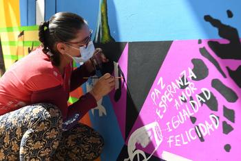 一名妇女在画以哥伦比亚和平与和解为主题的壁画。