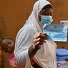 امرأة ترفع شهادة تطعيم ضد مرض كوفيد -19 في مركز صحي في منطقة أوباسين في بوركينا فاسو.