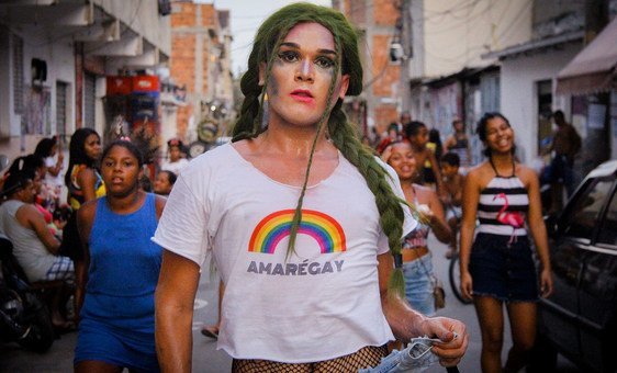 Grita en la favela. Un acitivista con una camiseta donde se lee un logo con la palabra Amarégay, un juego de palabras que usa el nombre de la Favela da Maré, que significa que el amor es gay y Maré es gay.