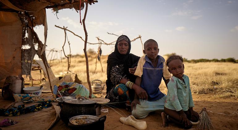 A displaced family sit in front of their tent at an informal camp in Bagoundié in Mali.