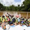 Des réfugiés ivoiriens saluent leurs amis et leur famille depuis une barge qui les ramène du Liberia en Côte d'Ivoire.