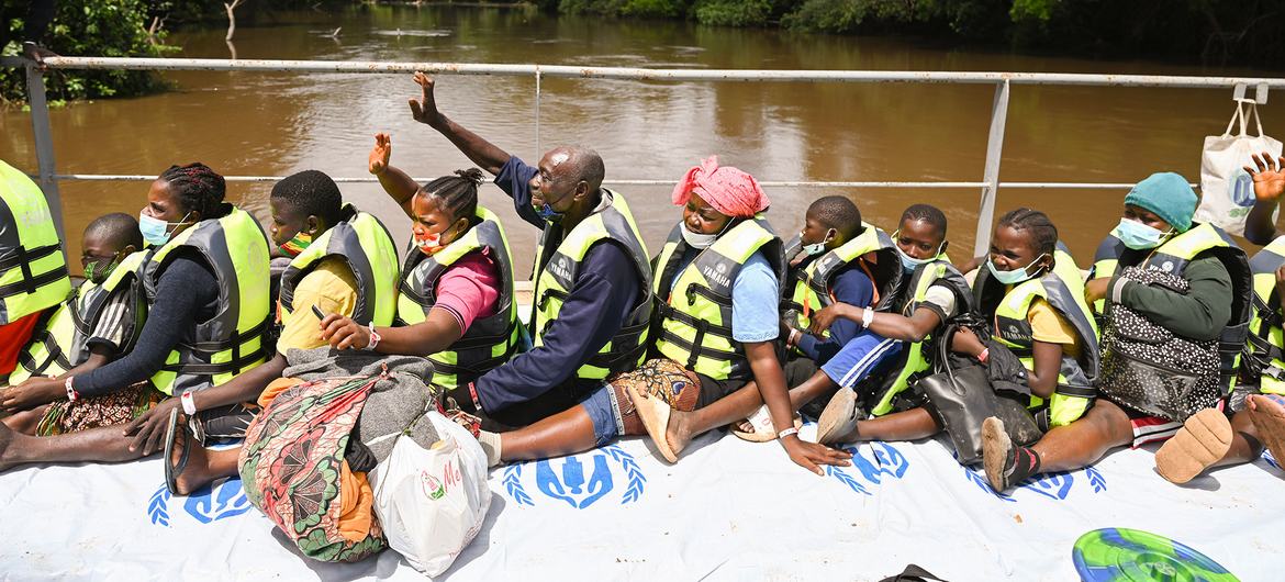 Ivorian refugees wave to waiting friends and family from a barge carrying them from Liberia back to Côte d’Ivoire.