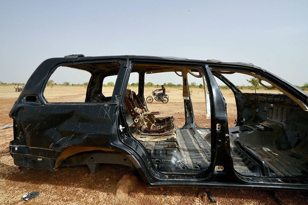 Un homme passe en moto devant un véhicule brûlé dans le nord du Burkina Faso où l'insécurité n'a cessé d'augmenter en 2019 (photo d'archives).