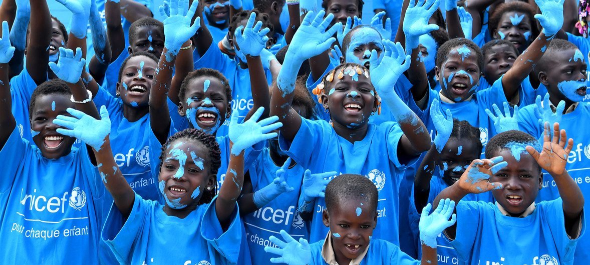 Niños de Costa de Marfil se pintan de azul en la celebración del Día Universal del Niño. Su escuela está hecha con ladrillos de plástico.