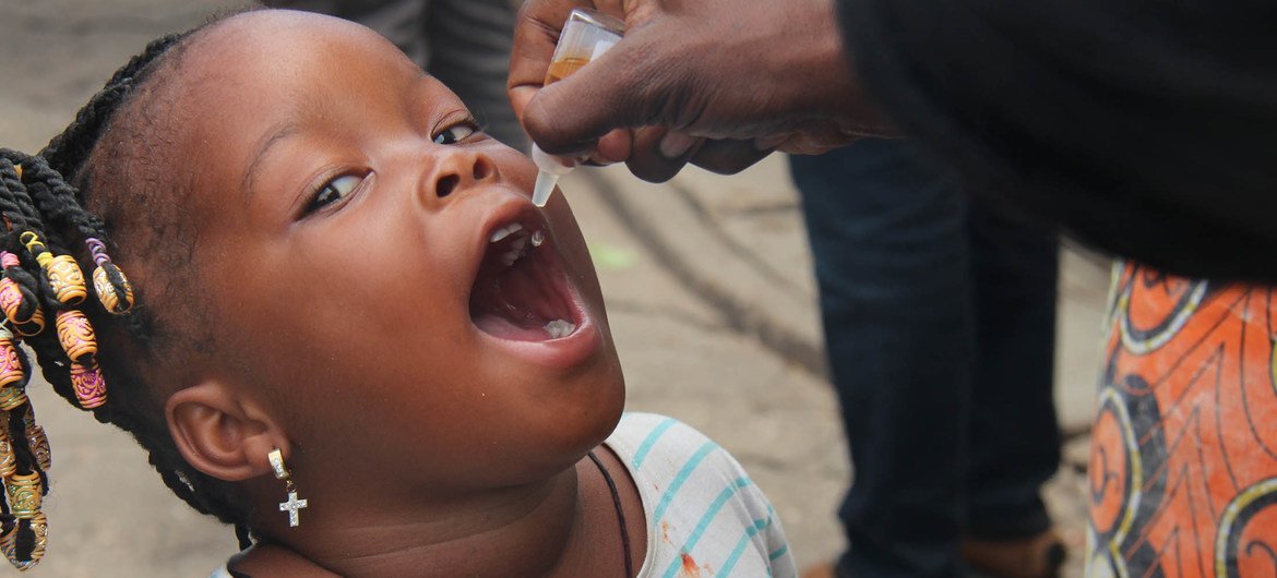 Vaccination d'un enfant de moins de 5 ans contre la polio au marché St Michel à Cotonou au Bénin.