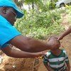 Spécialiste en vaccination au bureau de l’UNICEF en Côte d’Ivoire, le Docteur Epa Kouakou administre des vaccins à un jeune enfant ivoirien.