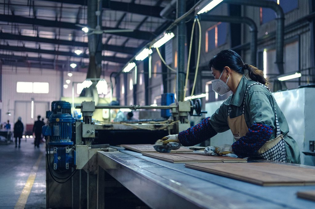在中国浙江的一个木地板工厂，一名工人正在清洁成品。
