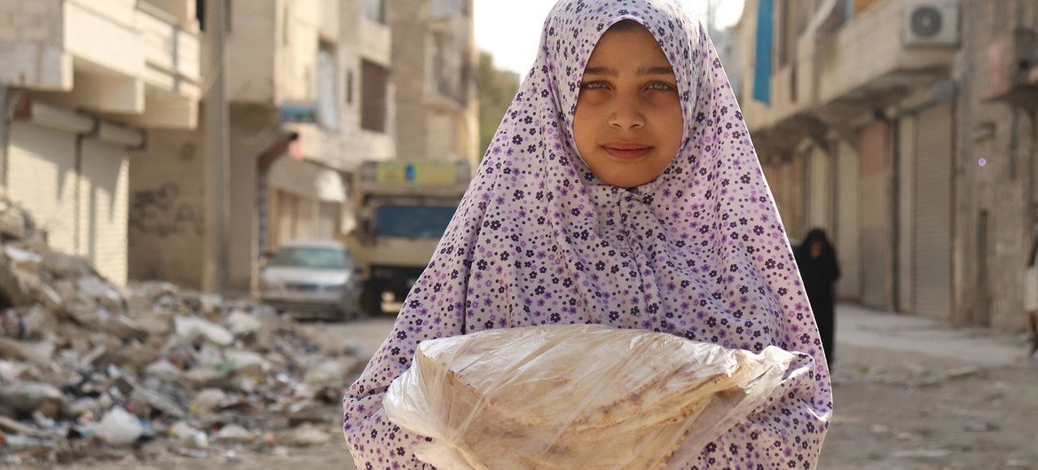 برنامج الأغذية العالمي يوزع الأغذية على السكان المحتاجين في حلب في سوريا لضمان درايتهم بطرق الوقاية من كوفيد-19