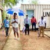 Kundi la walimu na wafanyakazi katika Radio Miraya, Sudan Kusini, wakiwa wamesimama nje ya jengo UN wakiwa na beji za utambulisho na miavuli.