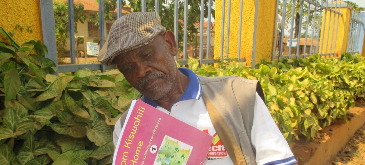 Peter Semiga, un hombre de edad de Uganda, leyendo un libro.
