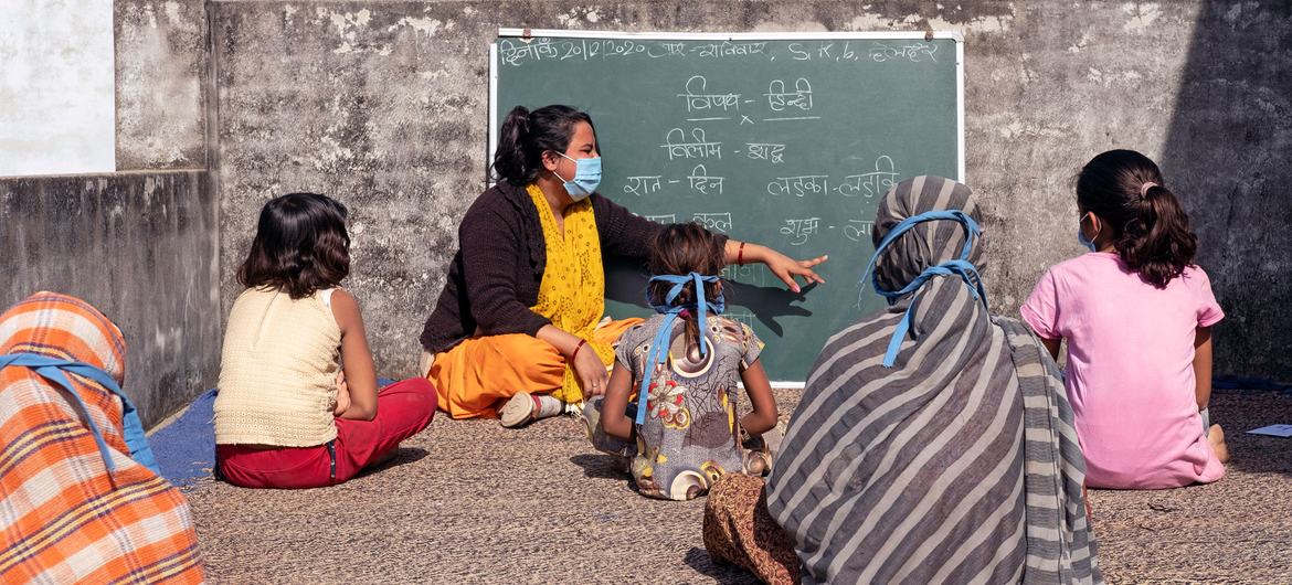 I bambini praticano il distanziamento sociale durante le lezioni in India.