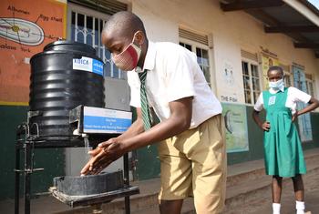 Mukasa Herbert, un élève de l'école maternelle et primaire de Nakivubo Settlement en Ouganda, se lave les mains le premier jour de la réouverture de l'école, le 10 janvier 2022.