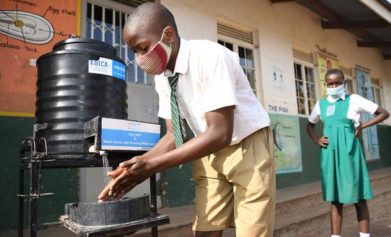 Estudante de escola no Uganda lava as maos. 