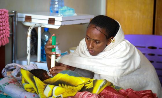 Etiyopya'daki bir klinikte bir anne, ciddi şekilde yetersiz beslenen bebeğini besliyor.