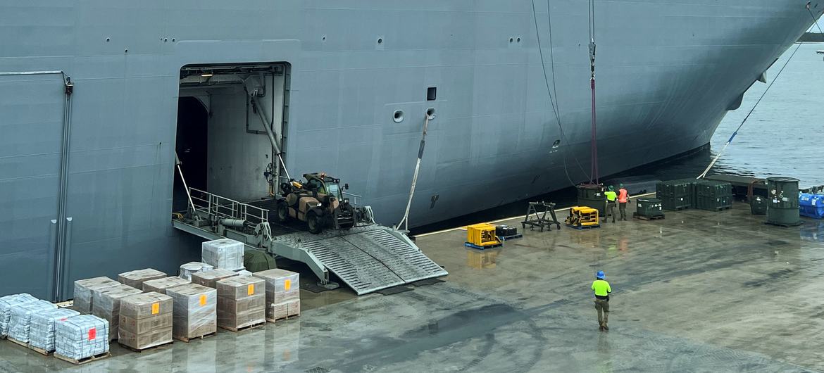 Workers load the HMAS Adelaide ship  with emergency supplies dedicated to Tonga Islands in response to the eruption of the Hunga-Tonga-Hunga-Ha'apai underwater volcano.