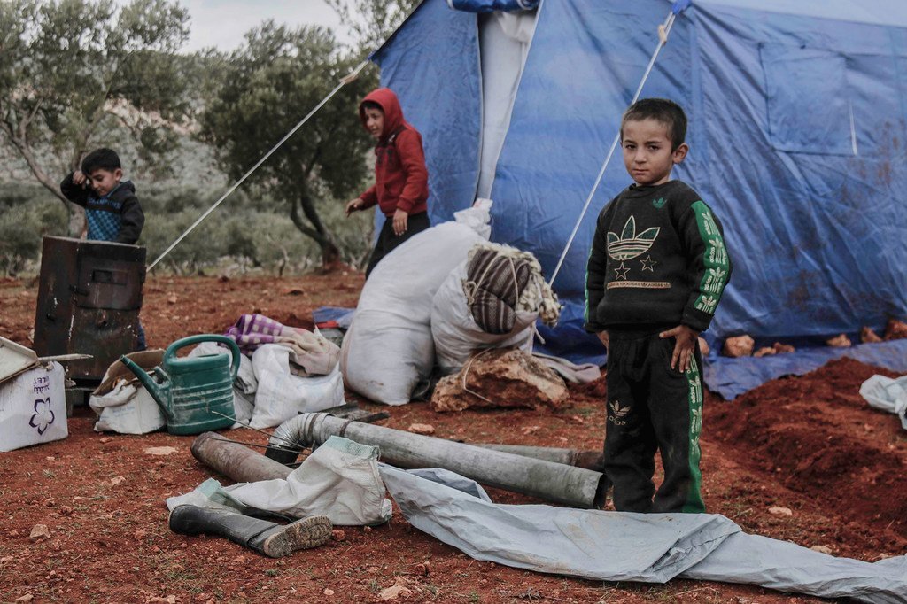 Children play outside a tent in a camp for displaced people in Idlib, Syria.
