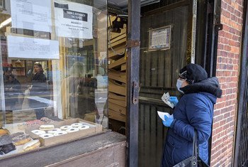 الصحفيون يقومون بتغطية الأزمة الصحية المترتبة على فيروس كورونا في جميع أنحاء العالم. في الصورة: سيّدة تنتظر أمام محل يبيع الفطائر في نيويورك