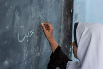 طالبة تكتب على اللوح في مدينة هيرات، أفغانستان.