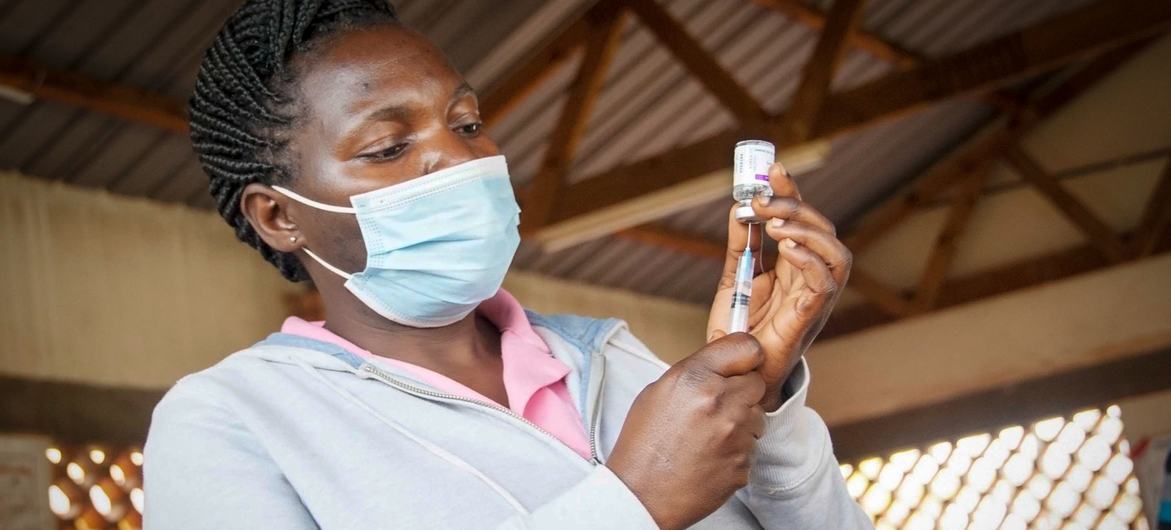 यूगाण्डा में एक स्वास्थ्यकर्मी, कोविड-19 का टीका लगाने की तैयारी करते हुए.