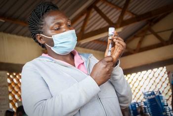 A health worker prepares to carry out a COVID-19 vaccination in Uganda.
