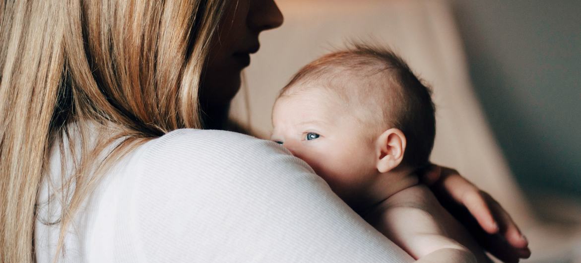 Una madre sostiene en sus brazos a su bebé recién nacido. 