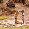 Uma criança puxando água de um poço em Bhor Rice Village, durante a estação das chuvas, na Índia